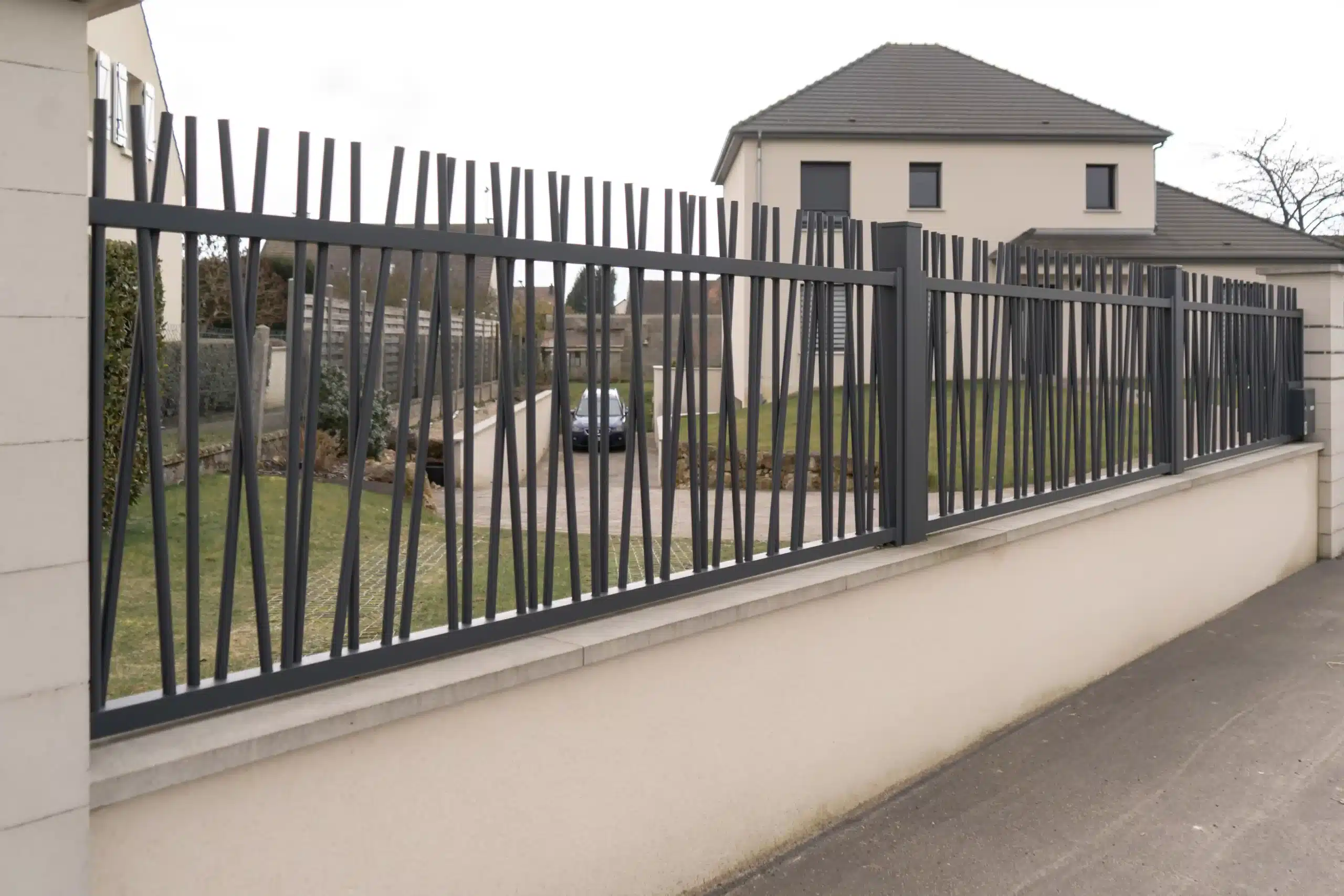 Clôture barreaudée moderne en acier installée sur muret
